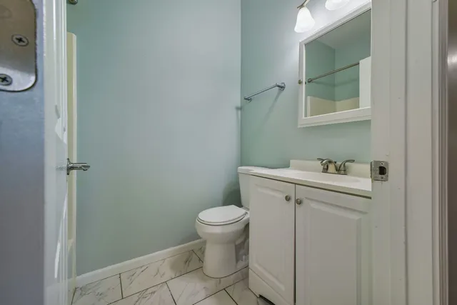 a bathroom with a sink toilet and a mirror