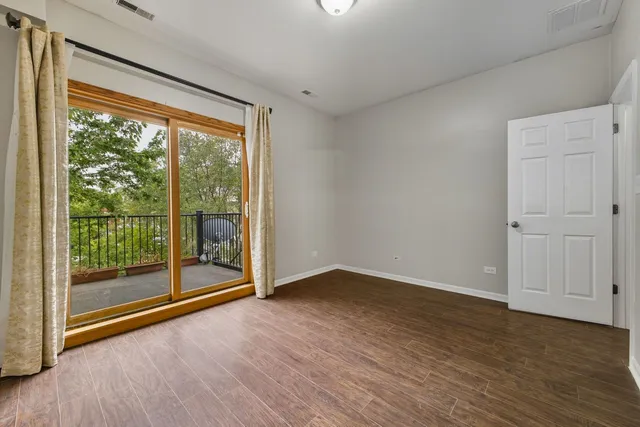 a view of a big room with wooden floor and doors