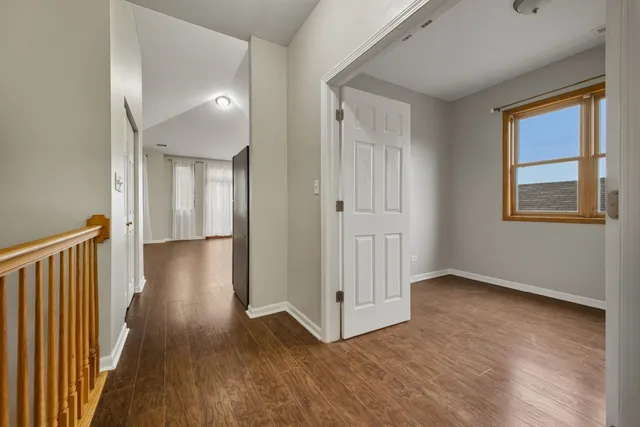 a view of a hallway with wooden floor and a window