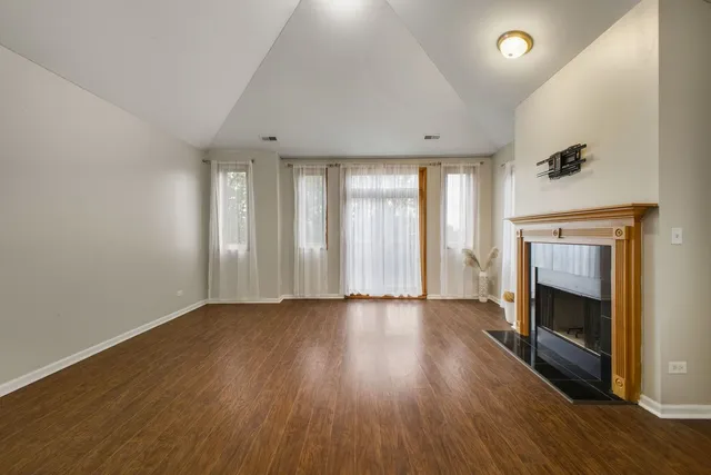 an empty room with wooden floor and fireplace