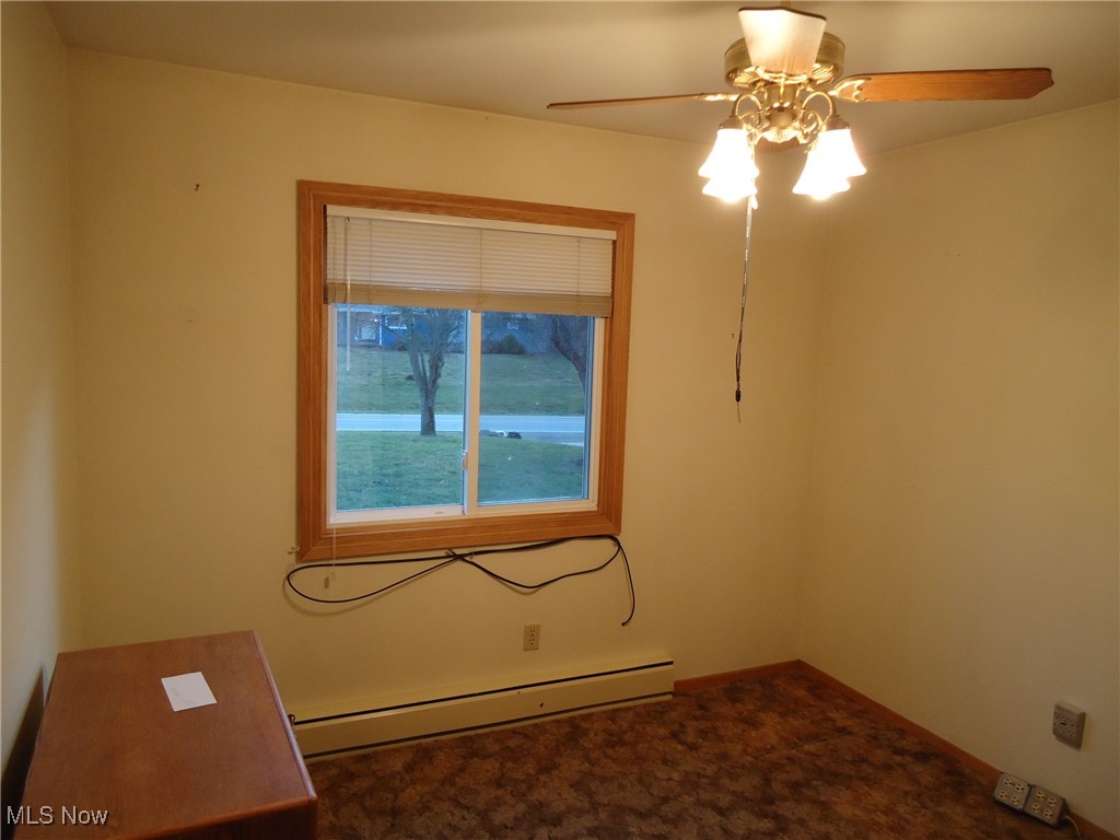 539 East Nimisila Road Uniontown, OH 44685 - Photo 31 of 41 Unfurnished room featuring carpet flooring, ceiling fan, and a baseboard heating unit