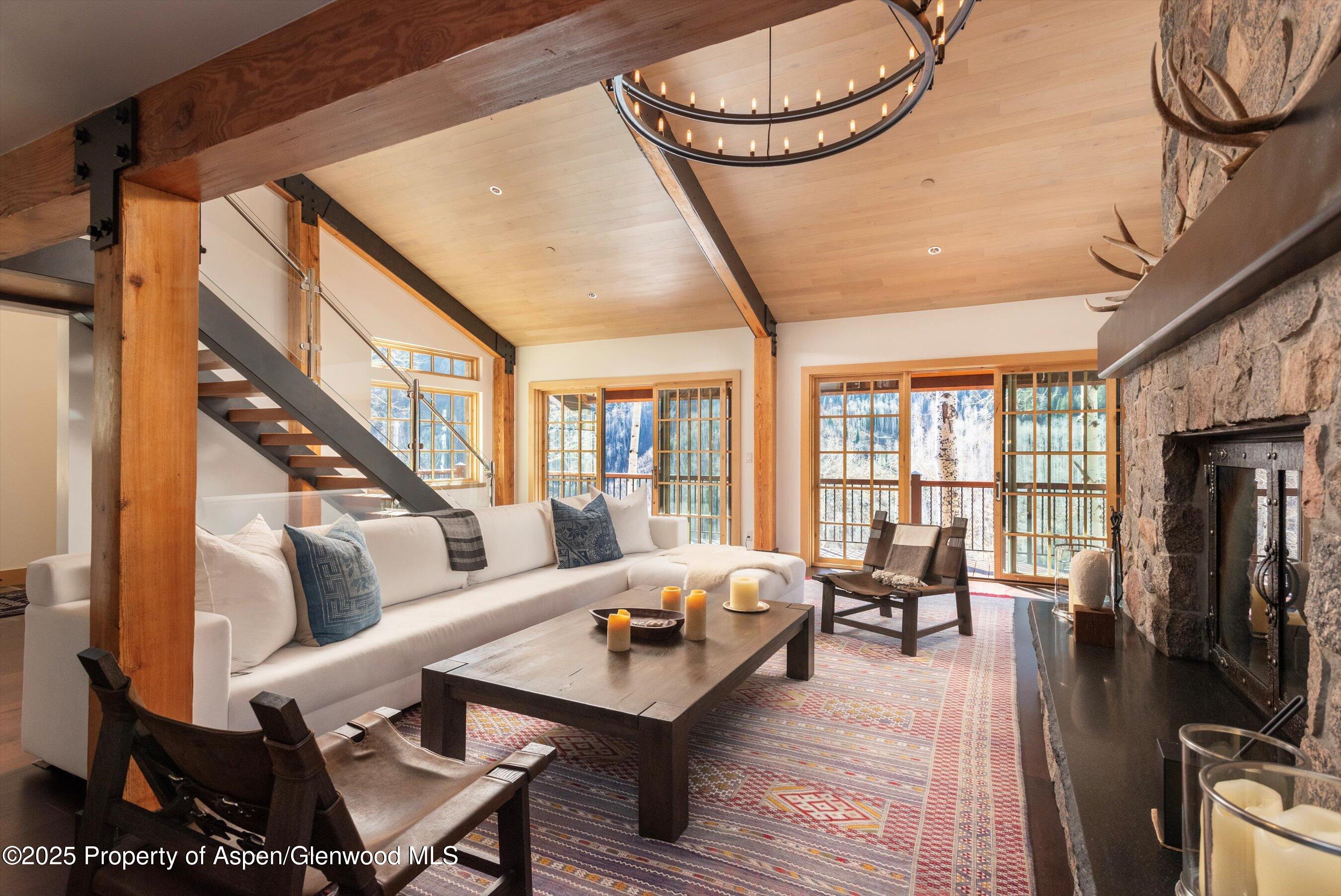 6770 Castle Creek Road Aspen, CO 81612 - Photo 9 of 53 a living room with furniture a fireplace and a floor to ceiling window