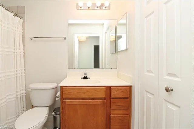 a bathroom with a toilet sink and mirror