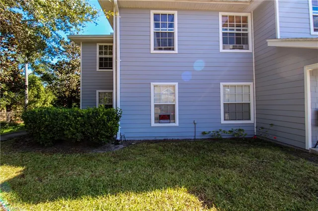 a view of a brick house next to a yard