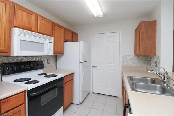 a kitchen with granite countertop a sink stove and refrigerator