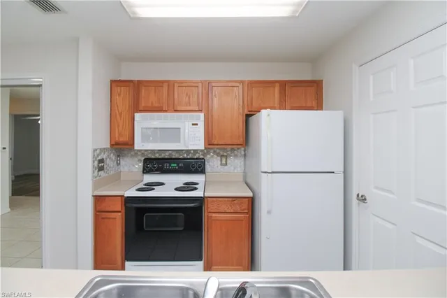 a kitchen with a refrigerator and a stove