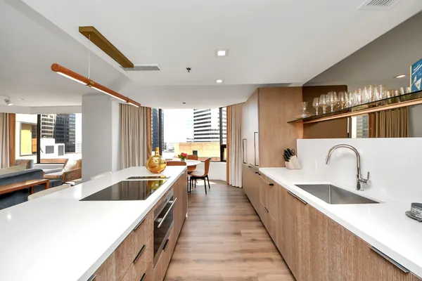 a kitchen with counter top space a sink wooden floor and stainless steel appliances