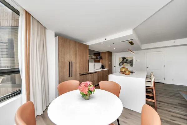 a large white kitchen with furniture and wooden floor