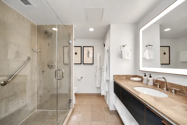 a spacious bathroom with a granite countertop sink mirror and shower