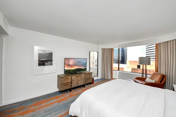 a bedroom with a bed and a large mirror