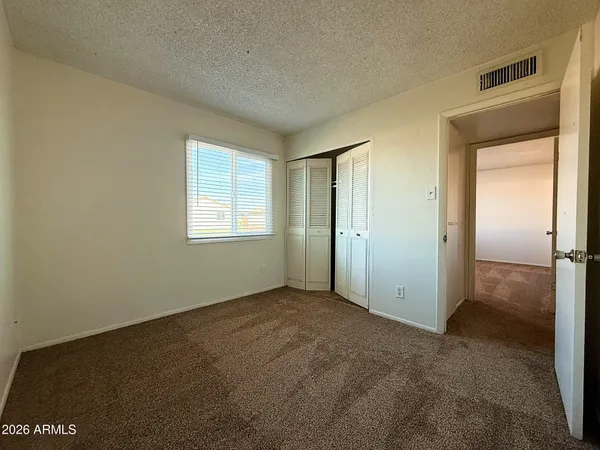 an empty room with windows and closet