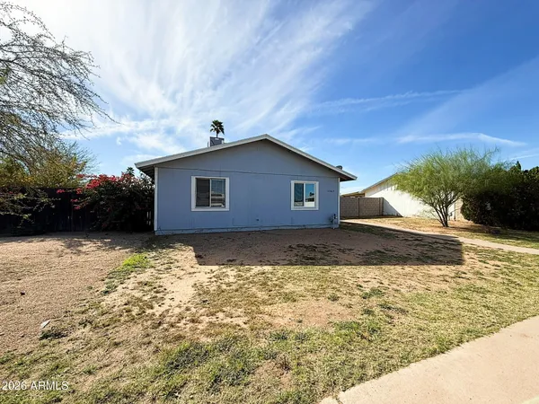 a view of house with backyard and trees