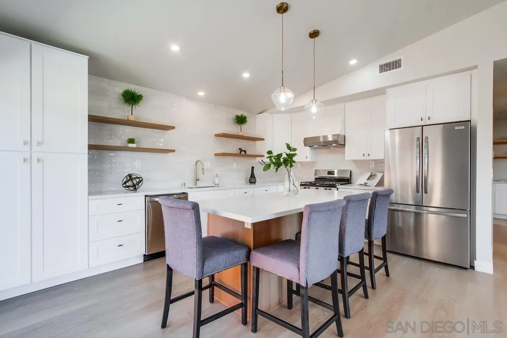 122 Lancer Avenue Oceanside, CA 92058 - Photo 11 of 67 a kitchen with stainless steel appliances a dining table chairs refrigerator and microwave
