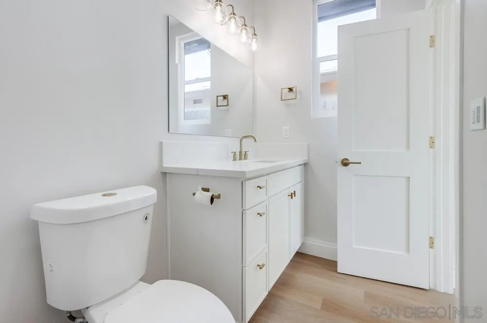 122 Lancer Avenue Oceanside, CA 92058 - Photo 45 of 67 a bathroom with a granite countertop toilet a sink and a mirror