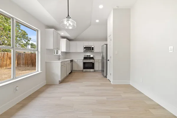 a view of a kitchen with a sink a refrigerator and window