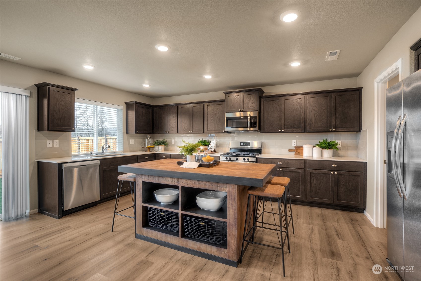 1055 17th Avenue, Unit 177 Sultan, WA 98294 - Photo 5 of 18 a kitchen with kitchen island granite countertop wooden floors stainless steel appliances and a sink