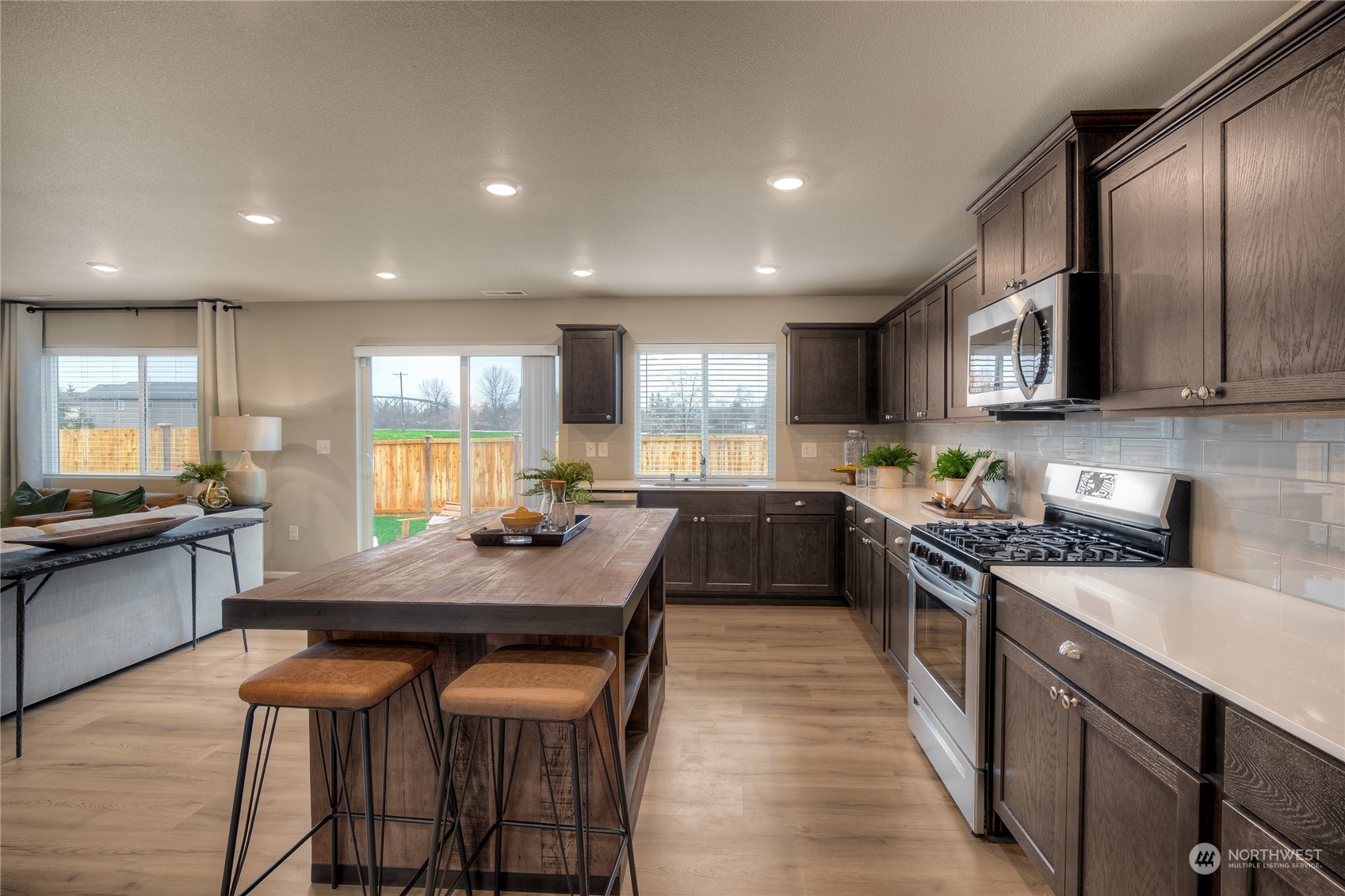 1055 17th Avenue, Unit 177 Sultan, WA 98294 - Photo 6 of 18 a kitchen with stainless steel appliances granite countertop table chairs sink refrigerator and stove