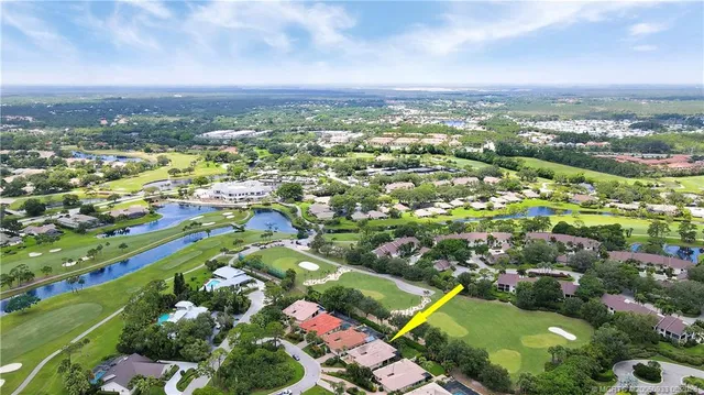 an aerial view of residential houses with outdoor space and lake view in back