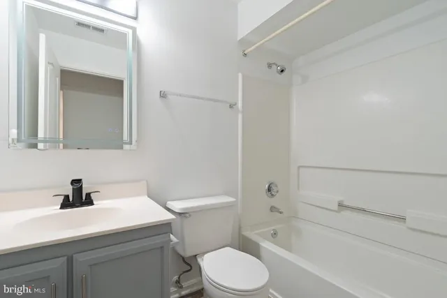 a white toilet sitting next to a bathroom sink