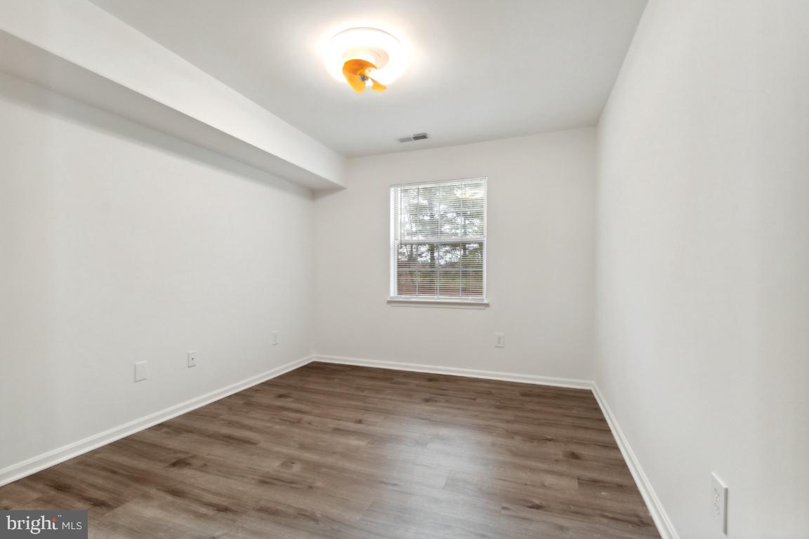 8573 Falls Run Road, Unit E Ellicott City, MD 21043 - Photo 12 of 21 an empty room with a window and wooden floor