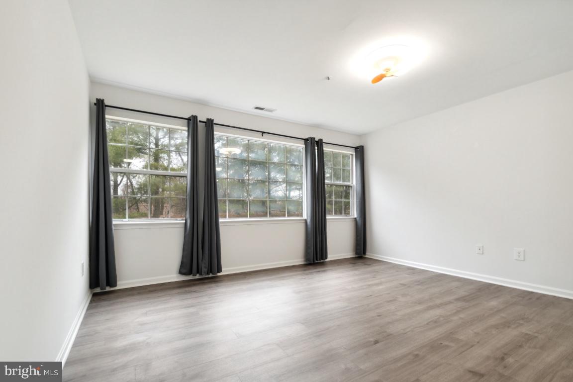 8573 Falls Run Road, Unit E Ellicott City, MD 21043 - Photo 16 of 21 a view of an empty room with wooden floor and a window