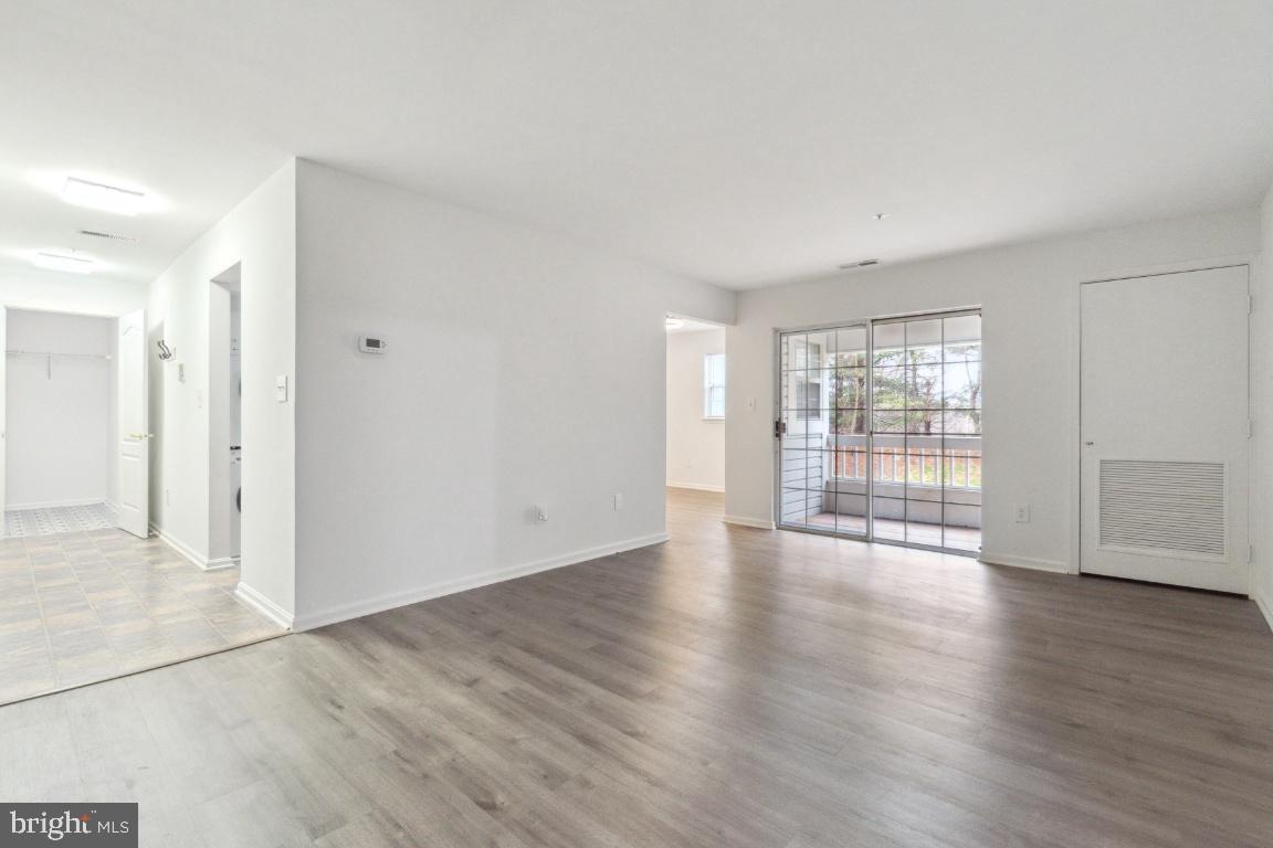 8573 Falls Run Road, Unit E Ellicott City, MD 21043 - Photo 3 of 21 wooden floor in an empty room with a window