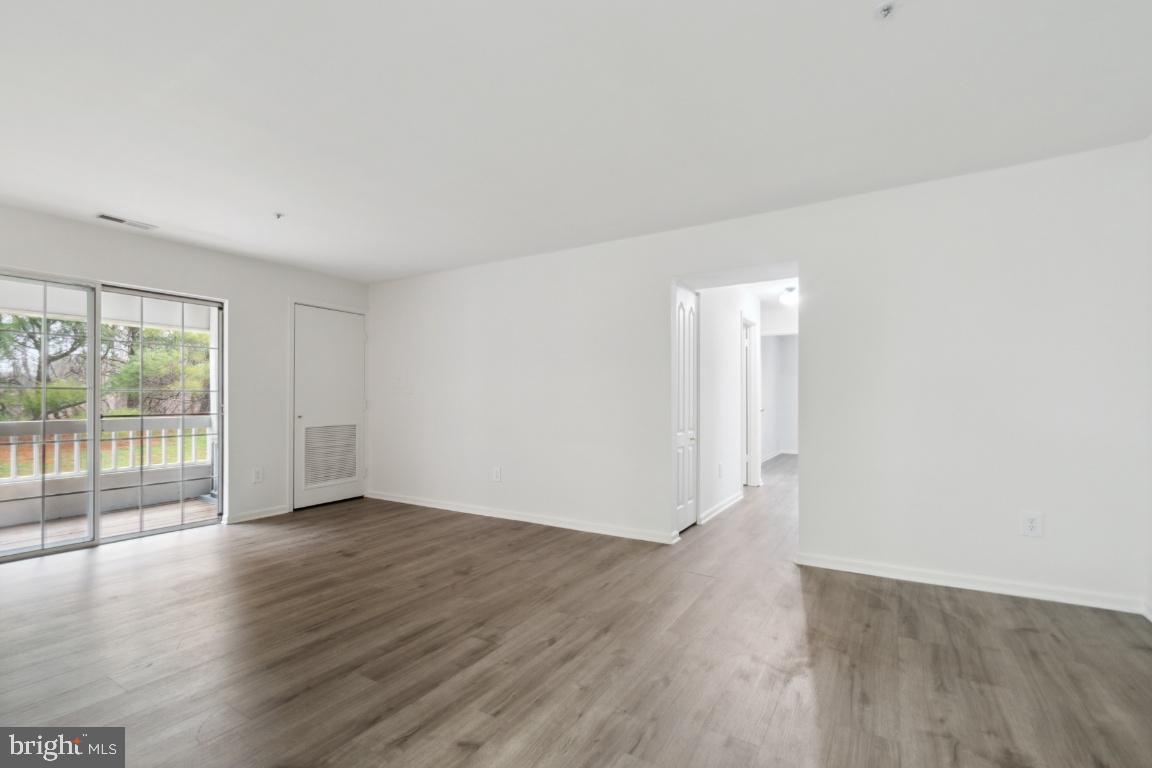 8573 Falls Run Road, Unit E Ellicott City, MD 21043 - Photo 4 of 21 a view of an empty room with wooden floor and a window