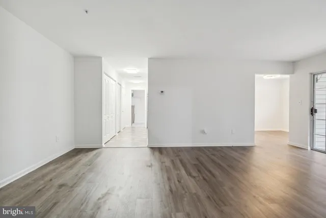 a view of an empty room with wooden floor