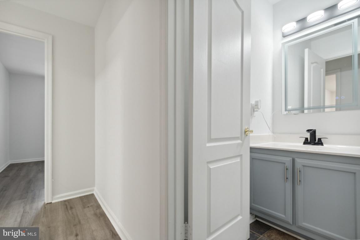 8573 Falls Run Road, Unit E Ellicott City, MD 21043 - Photo 10 of 21 a bathroom with a sink and mirror