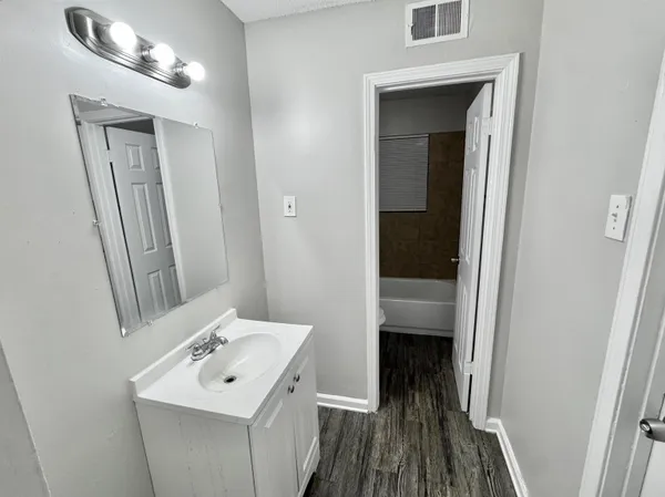 a bathroom with a sink a toilet and mirror