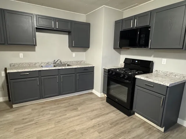 a kitchen with a sink stove and microwave