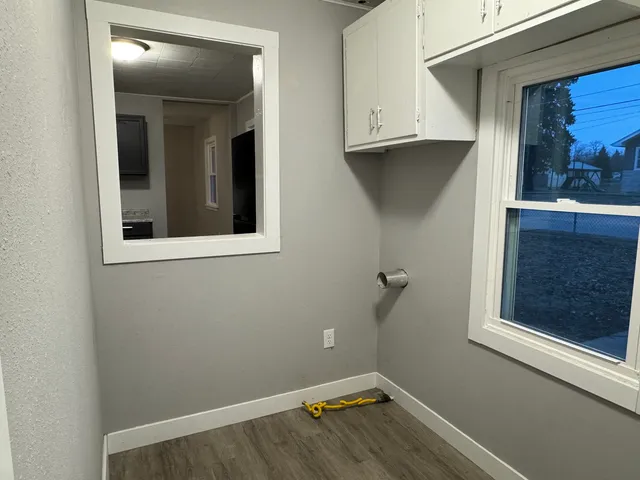 a view of a small space with wooden floor and a window