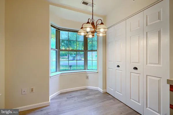 a view of a livingroom with a chandelier fan and windows