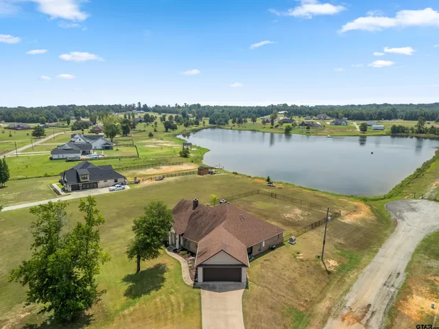 a kitchen with stainless steel appliances granite countertop a refrigerator a stove and a dining table with wooden floor