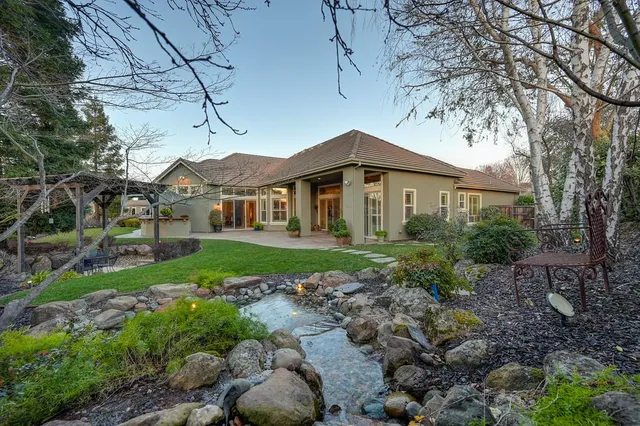 a view of a house with backyard and sitting area