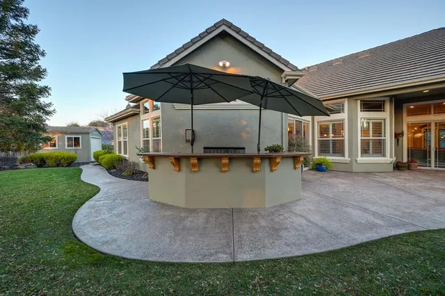 a front view of a house with a yard and mountain view in back