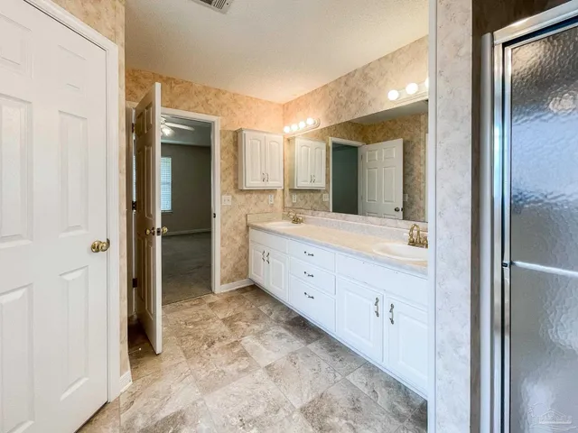 a bathroom with a double vanity sink mirror and shower