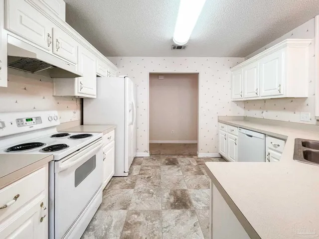 a kitchen with white cabinets and white appliances