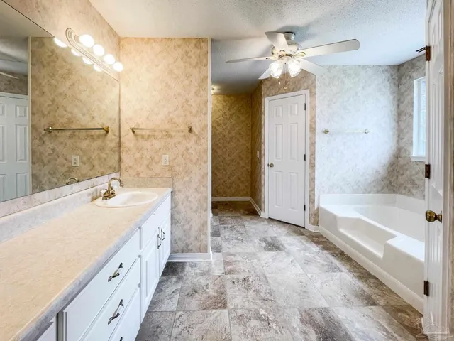 a spacious bathroom with a tub sink shower and mirror