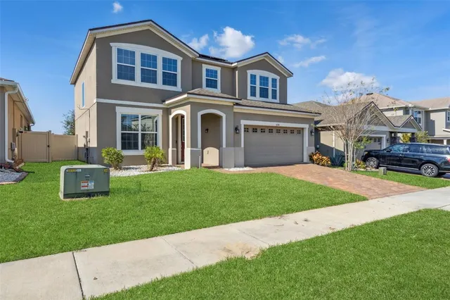 a front view of a house with a yard and garage