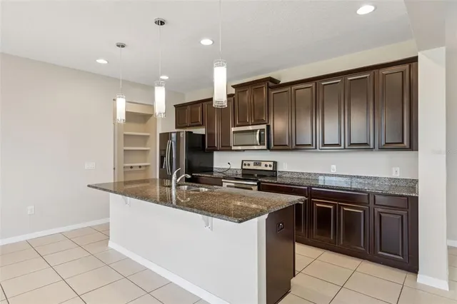 a kitchen with stainless steel appliances granite countertop a sink stove and microwave