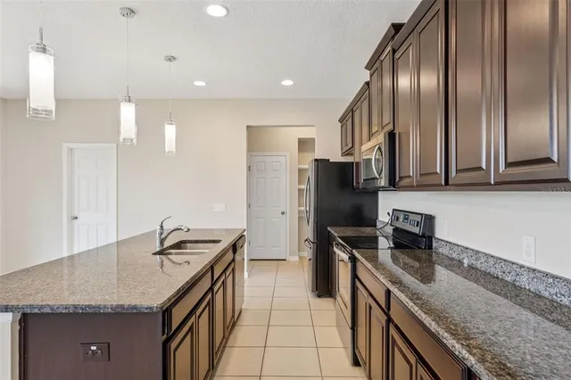 a kitchen with stainless steel appliances granite countertop a sink a stove and a refrigerator