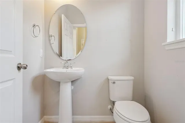 a bathroom with a toilet a sink and mirror