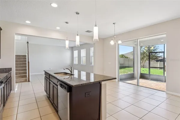 a kitchen with granite countertop a sink and a stove