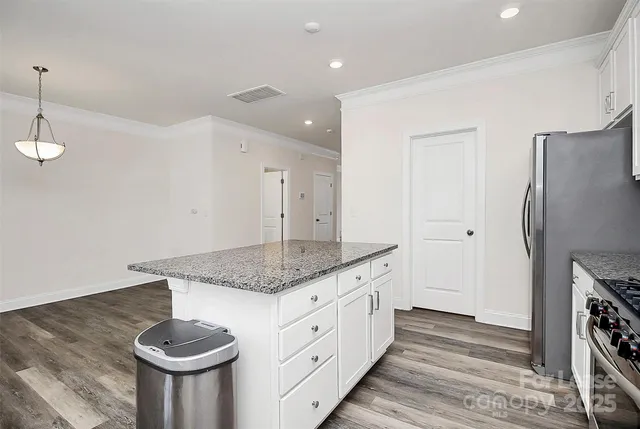 a kitchen with stainless steel appliances granite countertop a sink a refrigerator and a stove