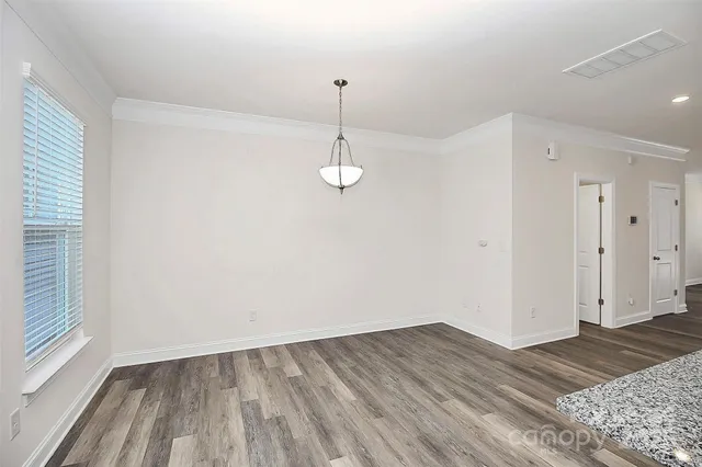a view of a room with wooden floor and white walls