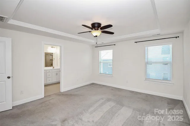 a view of a livingroom with a chandelier fan and windows