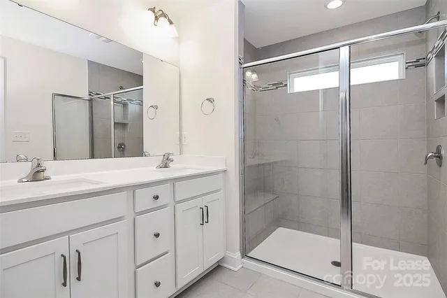 a bathroom with a shower sink and mirror