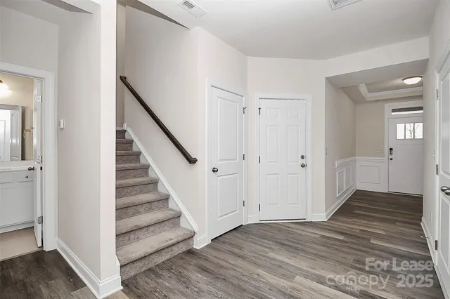 a view of a hallway with wooden floor and staircase