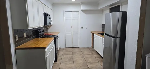 a kitchen with stainless steel appliances granite countertop a stove a microwave and a refrigerator